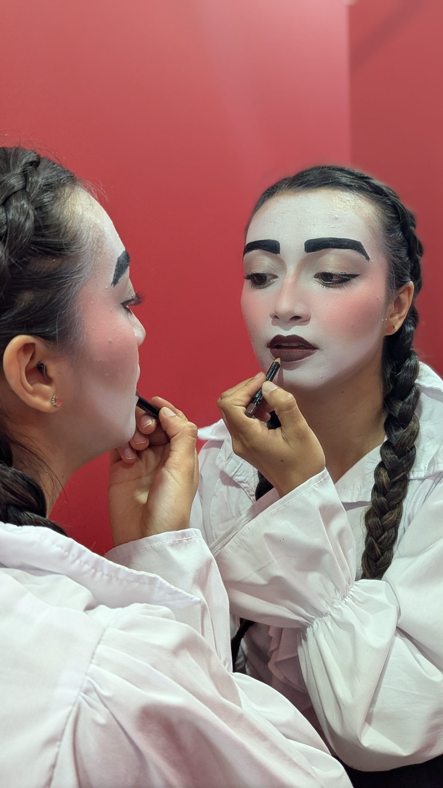 Actriz aplicándose maquillaje de clown frente al espejo